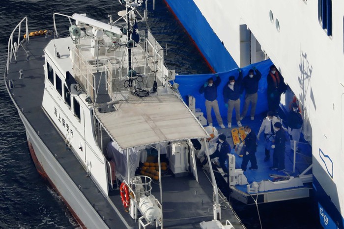 10 Penumpang Kapal Pesiar di Jepang Positif Corona Medical workers in protective suits take a passenger tested positive for a new coronavirus from the cruise ship Diamond Princess to ambulances at Yokohama Port in Yokohama, south of Tokyo, Wednesday, Feb. 5, 2020. Japan said Wednesday 10 people on the cruise ship have tested positive for the new virus and were being taken to hospitals. Health Minister Nobukatsu Kato said all the 3,700 people and passengers on the ship will be quarantined on board for up to 14 days under Japanese law. (Hiroko Harima/Kyodo News via AP)