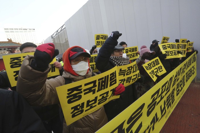 Police officers stand guard as protesters stage a rally calling for a ban on Chinese people entering South Korea in front of the Chinese embassy in Seoul, South Korea, Tuesday, Feb. 4, 2020. The death toll in mainland China from the new type of virus has risen to 425, with the total number of cases now standing at 20,438, officials said Tuesday. (AP Photo/Ahn Young-joon)