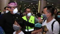 Wakil Gubernur Bali Tjokorda Oka Artha Ardana Sukawati (kiri) berbincang dengan penumpang pesawat maskapai China Southern Airlines tujuan Guangzhou, China, di Terminal Keberangkatan Internasional Bandara Internasional I Gusti Ngurah Rai, Bali, Selasa (4/2/2020). ANTARA FOTO/Fikri Yusuf.