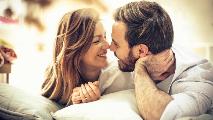 I love spending time with you. Young happy couple in bed. Space for copy. Cloe up.