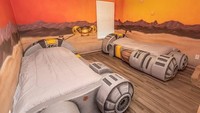 Kamar ini bertema podracing. Dua tempat tidur di kamar ini berbentuk jet, ditambah dinding berwarna oranye dan kuning. (Loma Homes)