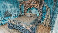 Nah, untuk kamar selanjutnya, traveler akan merasakan tidur di atas pohon berbonggol. Temboknya berwarna biru, ditambah gambar sebuah pohon yang timbul. (Loma House)