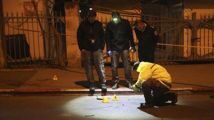 Israeli police officers inspect the scene of an attack in Jerusalem, early Thursday, Feb. 6, 2020. A Palestinian motorist slammed his car into a group of soldiers early on Thursday, wounding more than a dozen before fleeing the scene, Israeli police said. (AP Photo/Mahmoud Illean)