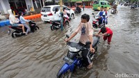 Sebagian dari mereka terpaksa mendorong motornya yang mogok akibat nekat terobos banjir.