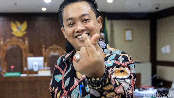 Eks asisten pribadi Menpora Imam Nahrawi, Miftahul Ulum memberikan gestur finger heart saat jalani sidang di Pengadilan Tipikor, Jakarta.