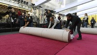 Beberapa pekerja tampak sudah menggelar karpet merah yang akan dilewati oleh para bintang-bintang Hollywood. Kevork Djansezian/Getty Images