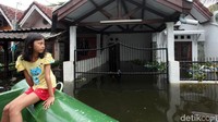 Seorang anak menaiki perahu karet untuk dapat beraktivitas saat rumahnya terendam banjir di kawasan Villa Mutiara Pluit, Tangerang, Kamis (6/2/2020).
