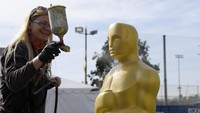 Seorang wanita terlihat tengah mengecat patung khas ajang penghargaan tertinggi di dunia film itu. Kevork Djansezian/Getty Images