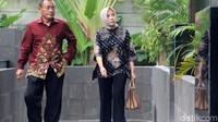 Rina Pertiwi datang dengan mengenakan batik. Dia juga menenteng tas.
