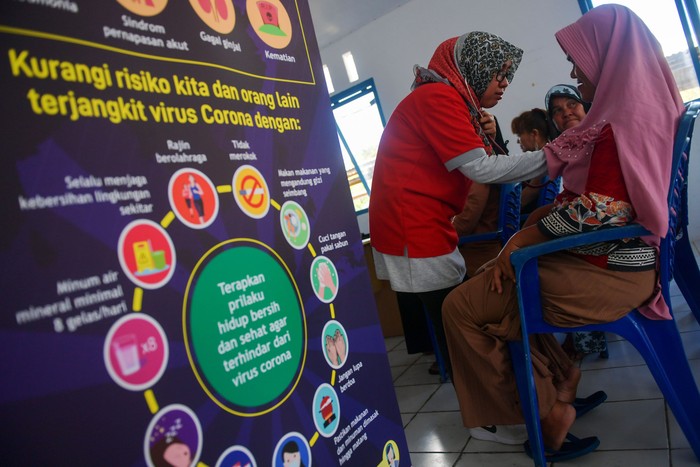 Dokter Spesialis Paru-Paru RS PMI Bogor Nancy Sovira (kiri)  menyemprotkan antiseptik pada warga saat sosialisasi pencegahan virus Corona di Kota Tua Penagi, Ranai, Natuna, Kepulauan Riau, Kamis (6/2/2020). Sosialisasi kesehatan tersebut sebagai bentuk kepedulian bagi warga yang tinggal berjarak sekitar satu kilometer dari tempat diobservasinya 238 WNI pascaevakuasi dari Wuhan, Hubei, China yang memasuki hari kelima dalam keadaan sehat dan baik. ANTARA FOTO/M Risyal Hidayat/wsj.