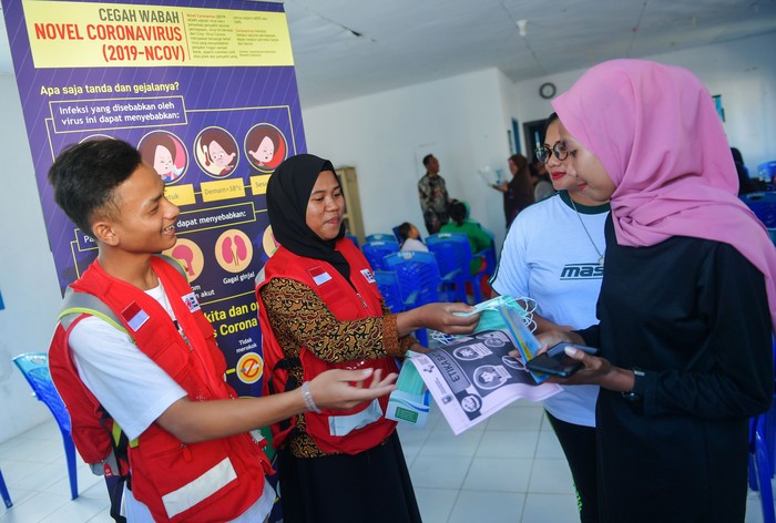 PMI SOSIALISASI CEGAH WABAH VIRUS CORONA Dokter Spesialis Paru-Paru RS PMI Bogor Nancy Sovira (kiri) menyemprotkan antiseptik pada warga saat sosialisasi pencegahan virus Corona di Kota Tua Penagi, Ranai, Natuna, Kepulauan Riau, Kamis (6/2/2020). Sosialisasi kesehatan tersebut sebagai bentuk kepedulian bagi warga yang tinggal berjarak sekitar satu kilometer dari tempat diobservasinya 238 WNI pascaevakuasi dari Wuhan, Hubei, China yang memasuki hari kelima dalam keadaan sehat dan baik. ANTARA FOTO/M Risyal Hidayat/wsj.