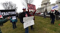 Dengan membawa sejumlah poster sejumlah aktivis berkumpul di Capitol Hill guna melakukan aksi setelah senat meloloskan Trump dari pemakzulan. AP Photo/Alex Brandon.