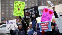 Sejumlah warga menggelar aksi di depan Gedung Federal Wallace F. Bennett di Salt Lake City untuk memberikan dukungan kepada senator dari Partai Republik Mitt Romney yang menyatakan Presiden Amerika Serikat Donald Trump menyalahgunakan kekuasaan dalam sidang pemakzulan Trump, Rabu (5/2/2020) waktu setempat. Scott G Winterton/The Deseret News via AP.