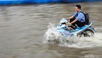 Seorang pelajar nekat menerobos banjir menggunakan sepeda motornya, Kamis (6/2/2020).