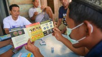 Seorang warga membaca pamflet yang berisi tentang pencegahan virus corona.