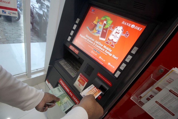Seorang mahasiswa tengah melakukan transaksi penarikan uang tunai dengan nominal Rp20.000,- di ATM Bank DKI di Universitas Pamulang, Tangerang Selatan (6/2/2020)