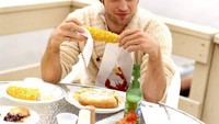Eitts! Jangan salah fokus sama senyum Robert Pattinson ya. Ia yang bersiap makan jagung terlihat tampan dengan sweater krem. Foto: Istimewa