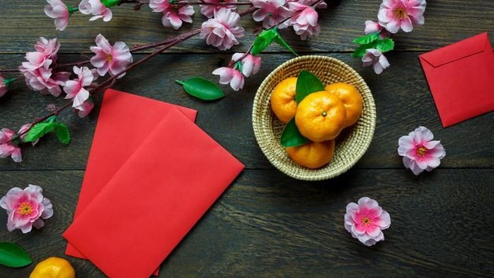 makanan cap go meh Top view accessories Chinese new year festival decorations.orange,leaf,wood basket,red packet,plum blossom on table wooden background with copy space.