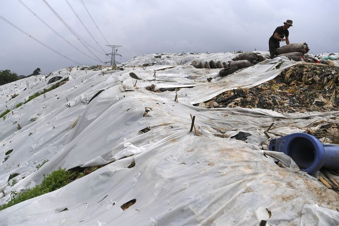 SAMPAH TPA CIPAYUNG DITUTUP PLASTIK Pekerja membawa sampah menggunakan gerobak melintasi plastik yang menutup tumpukan sampah di TPA Cipayung, Depok, Jawa Barat, Jumat (6/2/2020). Menurut pengelola, penutupan sebagian tumpukan sampah dengan plastik tersebut untuk mengurangi bau dan mengurung gas metan dari sampah. ANTARA FOTO/Wahyu Putro A/hp.