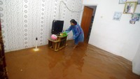 Warga enggan mengungsi meski banjir telah merendam rumahnya.