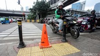 Meski telah dilengkapi dengan bollard dan kerucut lalu lintas (traffic cone), masih ada saja pengendara motor yang nekat melintasi jalur khusus pejalan kaki tersebut.