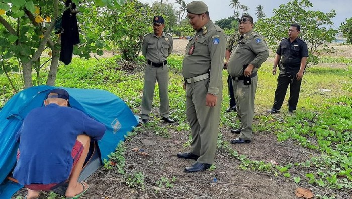 ISTIMEWA/ Tenda milik turis asal Denmark Jan Jonas Yakari Colom dibongkar Satpol PP di Pantai Kuta