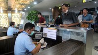Dua petugas Imigrasi memeriksa paspor penumpang pesawat yang tiba di Terminal Kedatangan Internasional Bandara Supadio di Kabupaten Kubu Raya, Kalimantan Barat, Kamis (6/2/2020). Antara Foto/Jessica Helena Wuysang.