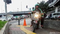 Seorang pengendara motor nekat melintasi jalur khusus pejalan kaki agar terhindar dari lampu merah dan mempersingkat waktu perjalanan.