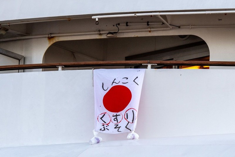 YOKOHAMA, JAPAN - FEBRUARY 07: A passenger jogs on the spot as another stretches as they wait on the balconies of their cabins on the Diamond Princess cruise ship as it sits docked at Daikoku Pier where it is being resupplied and newly diagnosed coronavirus cases taken for treatment as it remains in quarantine after a number of the 3,700 people on board were confirmed to have coronavirus, on February 7, 2020 in Yokohama, Japan. 61 passengers are confirmed to be infected with coronavirus as Japanese authorities continue screening people on board. The new cases bring the total number of confirmed infections to 86 in Japan, the largest number outside of China. (Photo by Carl Court/Getty Images)