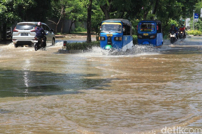 Pengendara melintasi banjir yang menggenangi Jalan Sunter Permai Raya atau di depan proyek pembangunan Stadion BMW, Jakarta Utara, Sabtu (8/2/2020).