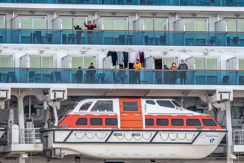 YOKOHAMA, JAPAN - FEBRUARY 07: A passenger jogs on the spot as another stretches as they wait on the balconies of their cabins on the Diamond Princess cruise ship as it sits docked at Daikoku Pier where it is being resupplied and newly diagnosed coronavirus cases taken for treatment as it remains in quarantine after a number of the 3,700 people on board were confirmed to have coronavirus, on February 7, 2020 in Yokohama, Japan. 61 passengers are confirmed to be infected with coronavirus as Japanese authorities continue screening people on board. The new cases bring the total number of confirmed infections to 86 in Japan, the largest number outside of China. (Photo by Carl Court/Getty Images)