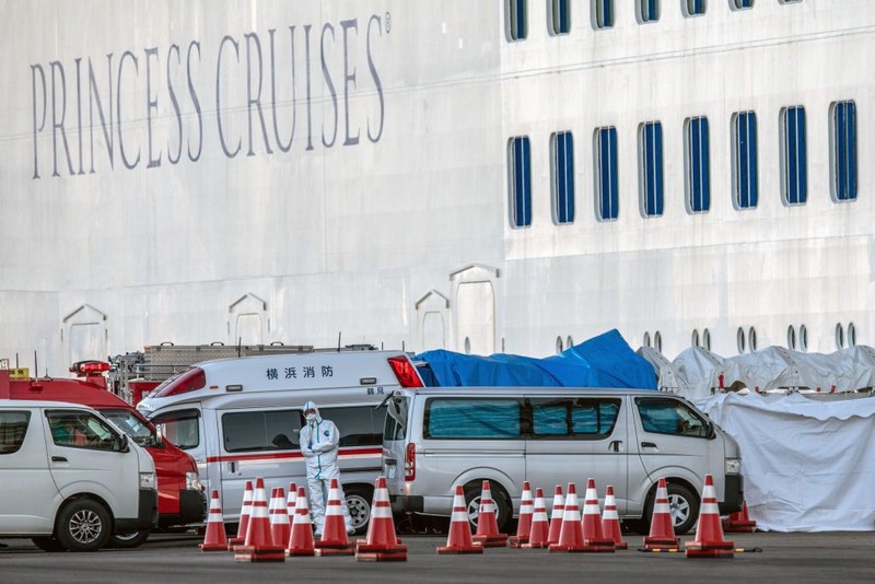 YOKOHAMA, JAPAN - FEBRUARY 07: A passenger jogs on the spot as another stretches as they wait on the balconies of their cabins on the Diamond Princess cruise ship as it sits docked at Daikoku Pier where it is being resupplied and newly diagnosed coronavirus cases taken for treatment as it remains in quarantine after a number of the 3,700 people on board were confirmed to have coronavirus, on February 7, 2020 in Yokohama, Japan. 61 passengers are confirmed to be infected with coronavirus as Japanese authorities continue screening people on board. The new cases bring the total number of confirmed infections to 86 in Japan, the largest number outside of China. (Photo by Carl Court/Getty Images)