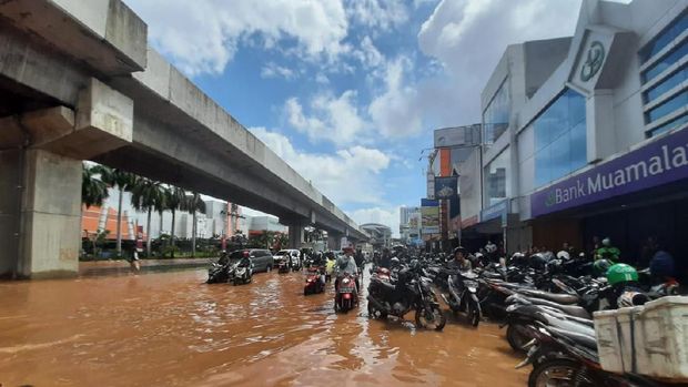Sejumlah pemotor menepi menunggu banjir surut.
