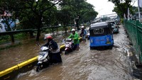 Beberapa pengendara memilih mendorong motornya saat melintasi banjir di Jalan Letjen Suprapto.