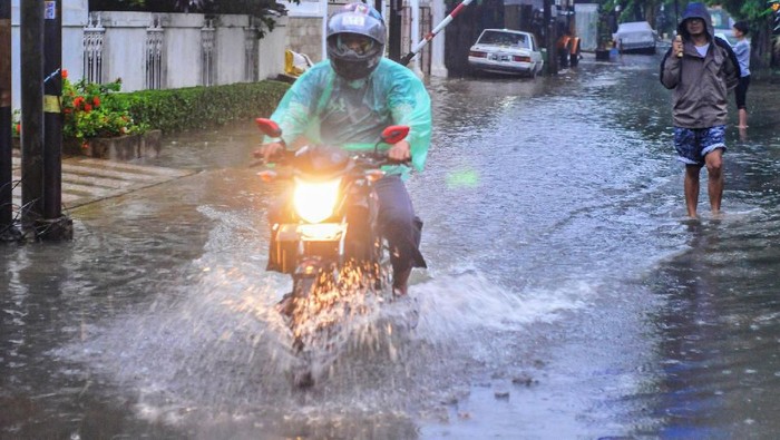 Pengendara sepeda motor melintas di jalan perumahan Komplek Ikip yang tergenang air di Duren Sawit, Jakarta Timur, Sabtu (8/2/2020). Genangan air setinggi 10-30 cm tersebut muncul akibat curah hujan yang tinggi dan saluran drainase menuju Kanal Banjir Timur yang buruk. ANTARA FOTO/ Fakhri Hermansyah