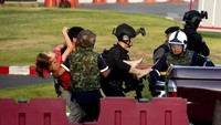 Sejumlah petugas mengankut seorang pengunjung keluar dari Mal Terminal 21 di Kota Korat, Thailand, terkait insiden penembakan yang terjadi di pusat perbelanjaan tersebut, Minggu (9/2/2020). AP Photo/Wason Wanicharkon.