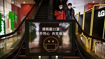 Sebuah layar yang menampilkan instruksi agar setiap orang selalu mengenakan masker pelindung di sebuah pusat perbelanjaan di Beijing, China. Foto: Getty Images