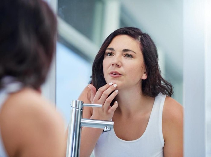 1155918959 Shot of an attractive young woman covering her eye with a beauty product in her bathroom at home