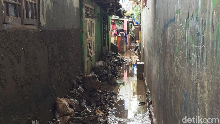 Warga di Jalan Kebon Pala ,Tanah Rendah, Kampung Melayu, membersihkan sisa-sisa banjir (Tiara Aliya Azzahra/detikcom)