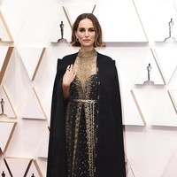 Gaun hitam beraksen emas Dior Haute Couture menjadi andalan Natalie Portman di Oscar 2020. Gaun tersebut dilengkapi jubah bergaya coat yang elegan. (Foto: Jordan Strauss/Invision/AP)