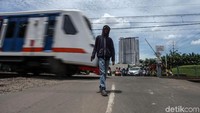 Perlintasan tanpa palang pintu otomatis ini dijaga oleh sejumlah relawan.