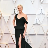 Gaun hitam struktural dari Dior Haute Couture menjadi andalan Charlize Theron. Train atau ekor panjang yang dramatis ikut menyempurnakan penampilan aktris asal Afrika Selatan ini. (Foto: Amy Sussman/Getty Images)