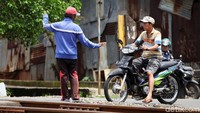 Relawan akan meminta pengendara berhenti saat kereta melintas di perlintasan tersebut.