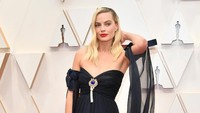 Margot tampil menawan dengan dress hitam berpotongan sabrina. Amy Sussman/Getty Images