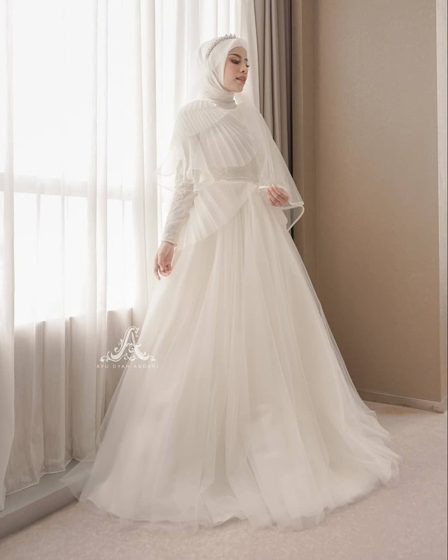 Saat akad nikah, Aghnia dan Nukky mengenakan busana yang bernuansa serba putih rancangan desainer Ayu Dyah Andari,Special Design Akad Wedding Gown for @aghniapunjabi wedding day made by Ayu Dyah Andari, tulis Ayu di akun Instagramnya @byayudyahandari. Foto: instagram @byayudyahandari