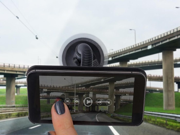 Personal perspective mature womans hand rewinding a dashboard camera app with flyover on display  Photo on display and ui by contributor