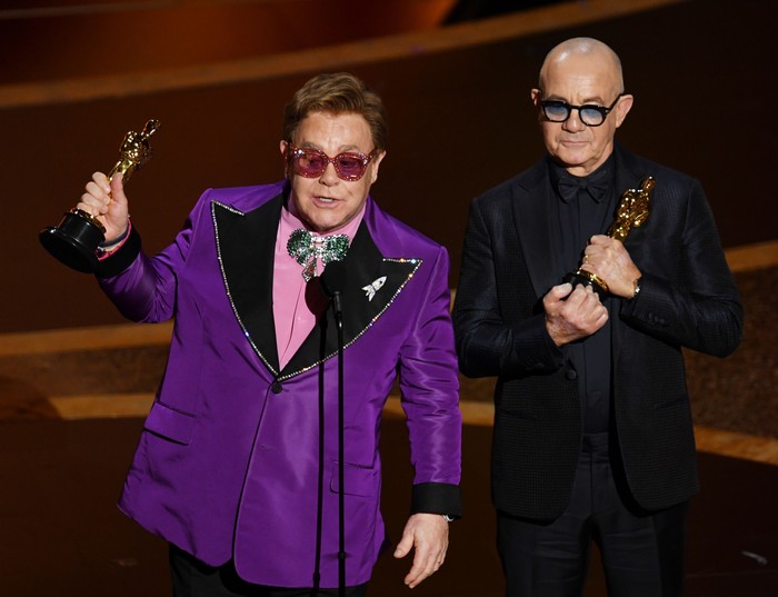 HOLLYWOOD, CALIFORNIA - FEBRUARY 09: (L-R) Elton John and Bernie Taupin accept the Music - Original Song - award for Im Gonna Love Me Again from Rocketman onstage during the 92nd Annual Academy Awards at Dolby Theatre on February 09, 2020 in Hollywood, California. (Photo by Kevin Winter/Getty Images)
