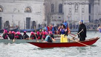 Para peserta karnaval menghiasi diri dan perahu dengan berbagai kostum unik nan menarik. Seperti dua orang peserta ini yang menghias diri mereka dengan kostum Putri Salju dan nenek sihir.