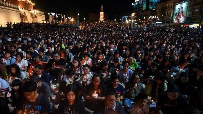 People gather for a candle light vigil following a deadly mass shooting in Nakhon Ratchasima on February 9, 2020. - A Thai soldier who killed at least 26 people before being shot dead in a mall by commandos went on the rampage because of a debt dispute, the kingdoms premier said on February 9, offering the first official speculation for the motive of an 