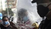 Begini penampakan seorang Pria di Hubei, China, Senin (10/2/2020) saat mengenakan penutup kepala menggunakan plastik.